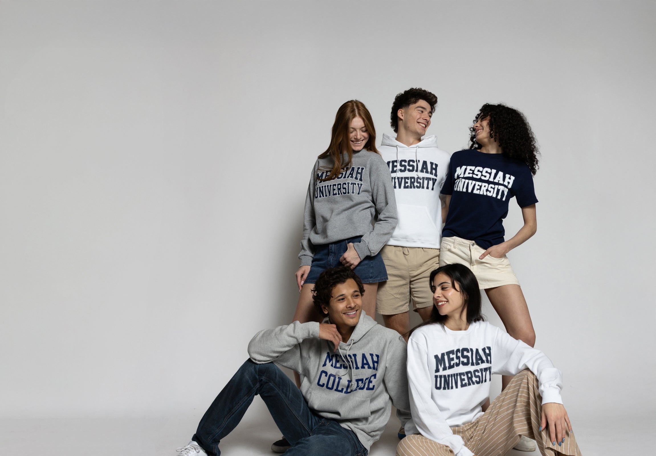 Five individuals wearing Messiah University apparel in front of a plain background